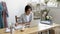 Busy female designer sitting by pc making notes in planner