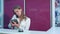 Busy female receptionist taking a phone call while holding tablet behind the counter in a hotel lobby