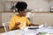 Busy freelance worker female read documents and eat at home office sit at table in kitchen in hurry