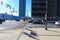 A busy intersection filled with cars stopped at a traffic signal with tall black light posts and bare winter trees