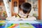 Busy little boy drawing using felt pens at home