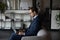 Busy male employee using laptop on sofa at coworking space