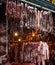 Busy market, showing a variety of preserved meat hanging from a large industrial roof