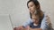 Busy mom with child on hands working on notebook. Working mother with baby at home.