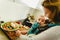 Busy mother preparing food in the kitchen while taking care of her baby, in a baby carrier using the kangaroo method