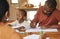 Busy and multitasking father talking on a call while taking care of his child at home. African american entrepreneur or