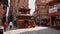 Busy scene around small pagoda temple in the narrow roads of tourist district Thamel in the center of Kathmandu.