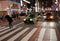 Busy Tokyo street at night with people crossing zebra way