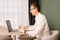 Busy workman in glasses, white shirt staring at monitor of computer, operating, sit at desk with glass of drink near.