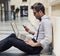 Busy young businessman working in the lobby