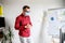 Busy young man in medical mask stands in office