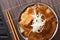 Butadon pork bowl, is a Japanese dish consisting of a bowl of rice topped with pork simmered in a mildly sweet sauce close-up in a