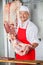 Butcher Carrying Meat In At Counter Butchery