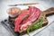 Butcher choise Bavette raw beef meat steak or flank flap on a wooden board with herbs. White background. Top view