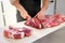 Butcher or cook slicing chuck steaks