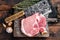 Butcher cutting board with Raw T-bone pork chop meat steak. Wooden background. Top view