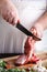 Butcher cutting lamb meat on kitchen