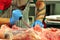 Butcher cutting off meat in a market in Florence, Italy