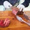 Butcher cutting slices of fresh beef