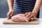 Butcher hands with raw meat pork shoulder