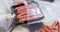 Butcher packing sausages in container