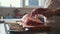 Butcher prepairs large piece of fresh raw meat lying on a wooden board in a commercial kitchen