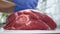 Butcher Put Gloves on His Hands Preparing for Cutting a Piece of Beef Meat