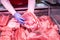 Butcher`s hands holding meat piece. Offering fresh meat at display in supermarket