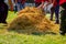 Butchers cover the pig with straw to burn hair from pork`s skin