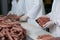 Butchers packing raw sausages