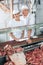 Butchers Standing At Meat Counter In Shop