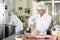 Butchery worker preparing slab of raw pork ribs for packaging