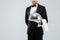 Butler in tuxedo and gloves holding silver tray with lid