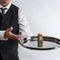 Butler / waiter holds a silver tray with a ten dollar bill.