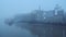 Butlers Wharf Pier and River Thames in thick fog and mist, on a cool blue morning in foggy and misty
