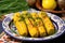 butter glazed sweet corn garnished with herbs on a vibrant ceramic plate