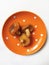 butter mushrooms on an orange plate on a white background