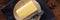 Butter panorama. A stick of butter with a knife on a plate, overhead
