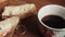 Butter on a piece rural bread and cup of coffee on a wooden old table. breakfast