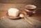 Butter on plate, clay pot and spoon on linen napkin. Rustic still life. Wooden background. TOned