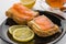 Butter sandwich, salted salmon and lemon on a black plate