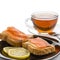 Butter sandwich, salted salmon and lemon on a black plate