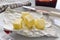 Butter slices with a knife on a white plate.