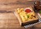 Buttered chicken nuggets and popcorn bites in vintage wooden box with ketchup and glass of cola on wooden background. Space for