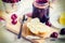 Buttered toasts and a jar with cherry homemade jam over white wood background