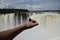 A butterfly sits on a tourist& x27;s arm against the backdrop of a waterfall. Puerto Iguazu, Argentina