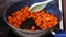 Butternut squash cubes getting sauteed and stirred in a pan on stovetop