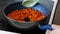 Butternut squash cubes getting sauteed and stirred in a pan on stovetop