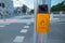 Button on a traffic light to allow pedestrians to cross the road with words stiskni or press written on it. Yellow box with a