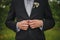 Buttoning a jacket hands close up. Stylish man in suit fastens buttons and straightens his jacket. Preparing for a wedding